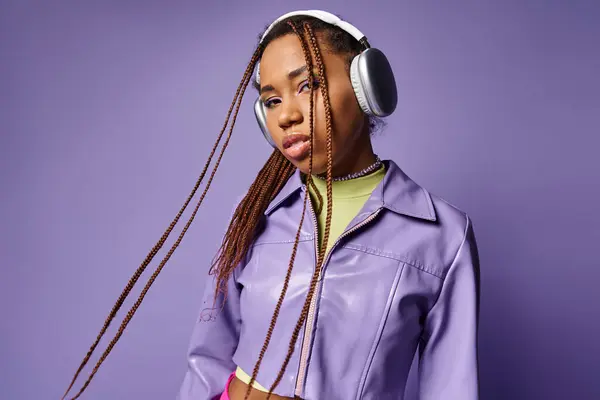 Giovane donna afroamericana con dreadlocks e cuffie wireless godendo della musica viola — Foto stock