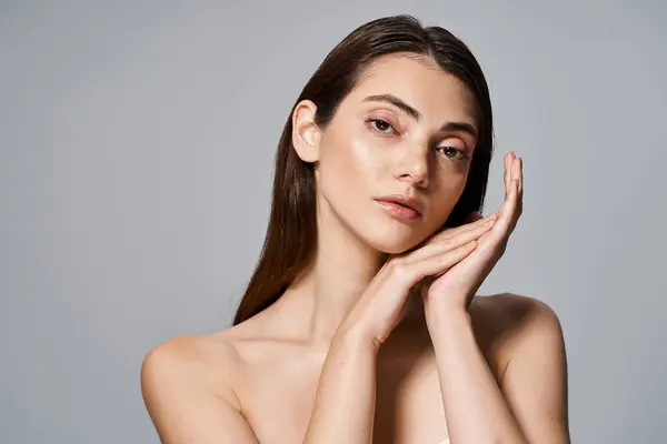 Young caucasian woman with brunette hair posing with hands on face, exuding introspection and grace. — Stock Photo