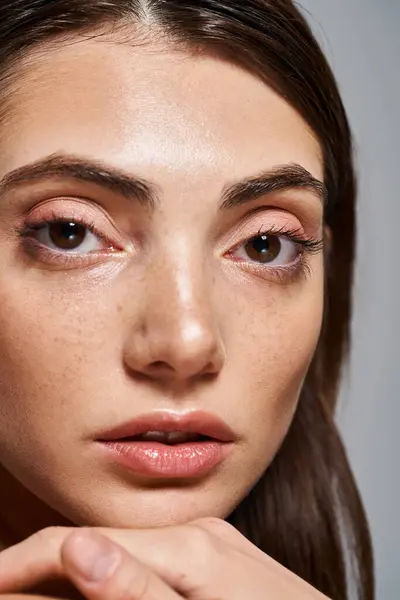Nahaufnahme einer jungen kaukasischen Frau mit hypnotisierenden braunen Augen und makelloser Haut in einem Studio-Setting. — Stockfoto