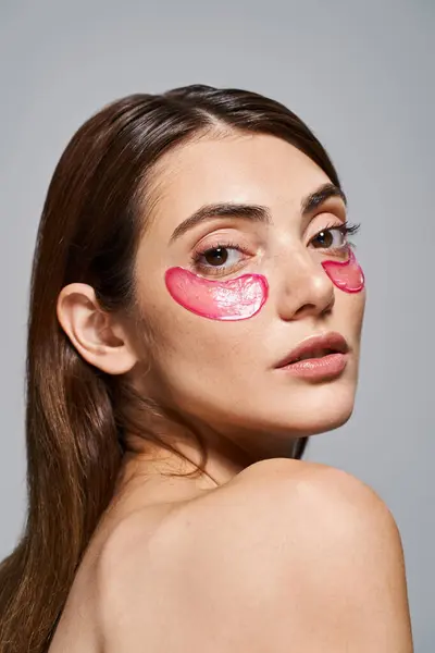 Крупним планом молода жінка з брюнеткою показує яскраві рожеві плями на її обличчі — стокове фото