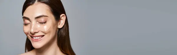 Eine junge kaukasische Frau mit braunen Haaren und makelloser Haut trägt unter Augenklappen ein Banner — Stockfoto