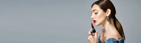 Une jeune femme caucasienne à la peau propre et aux cheveux bruns tient un rouge à lèvres dans sa main, exsudant élégance et beauté, bannière — Photo de stock