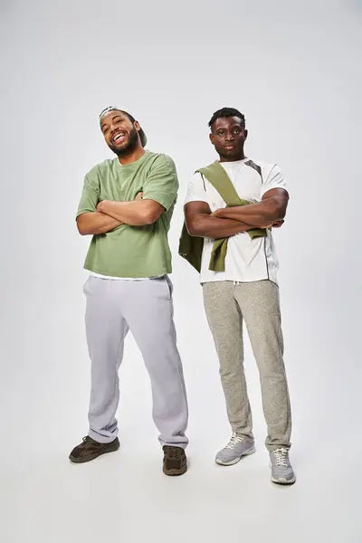 Juneteenth concept, deux amis afro-américains debout avec les bras croisés sur fond gris — Photo de stock