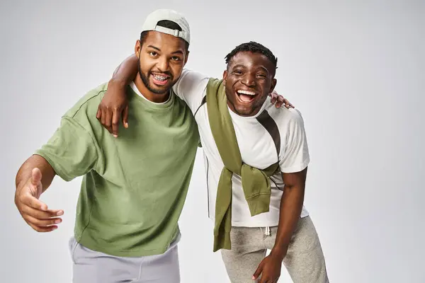 Happy Juneteenth celebration, positive and young african american friends hugging on grey background — Stock Photo