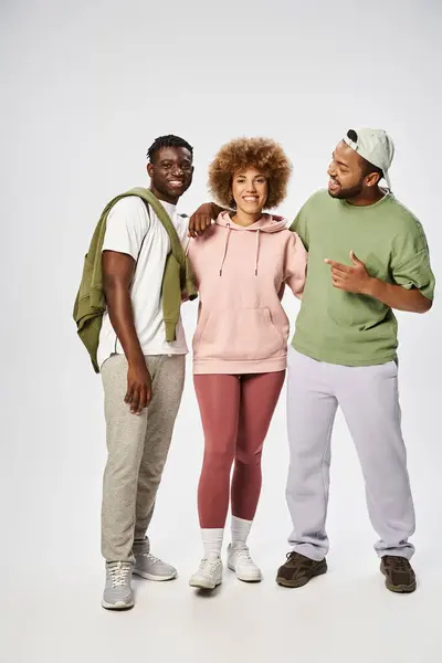 Allegri amici afroamericani in piedi insieme su sfondo grigio, celebrazione Juneteenth — Foto stock
