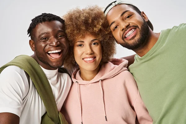 Amis afro-américains positifs regardant la caméra sur fond gris, Célébration du 10 juin — Photo de stock