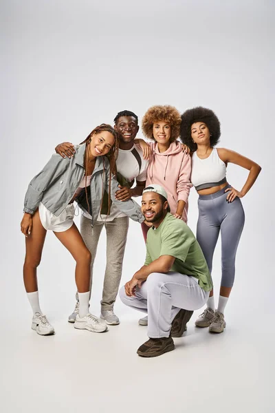 Cheerful african american men and women in sportswear standing together on grey backdrop, Juneteenth — Stock Photo