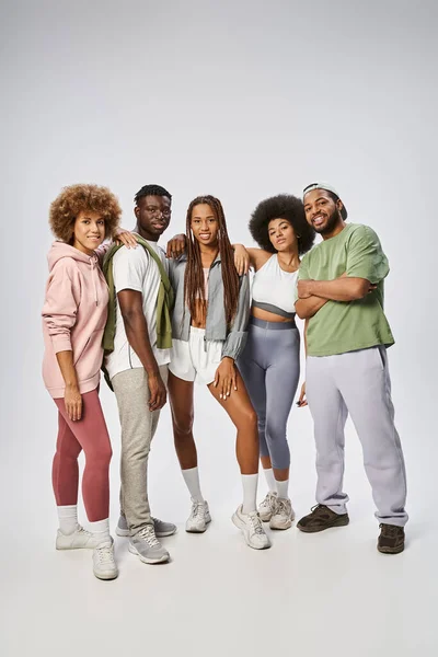 Cheerful african american friends in sportswear standing together on grey backdrop, Juneteenth — Stock Photo
