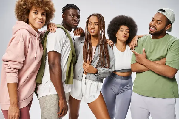 Optimistic african american friends in sportswear standing together on grey backdrop, Juneteenth — Stock Photo