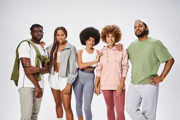 Grupo de afroamericanos felizes em sportswear pé juntos em fundo cinza, comunidade — Fotografia de Stock