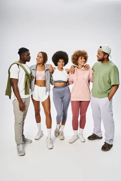 Groupe de jeunes amis afro-américains heureux debout ensemble sur fond gris, communauté — Photo de stock