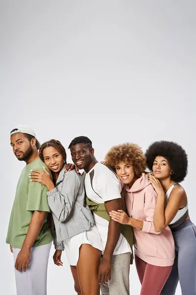 Group of positive young african american friends standing together on grey background, community — Stock Photo