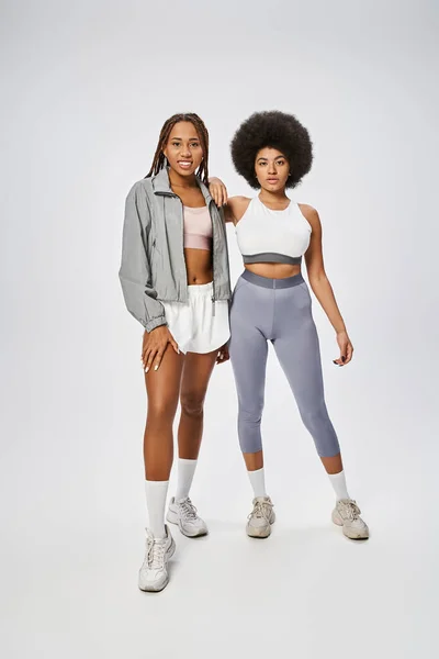 Jeunes femmes afro-américaines en forme debout ensemble sur fond gris, concept Juneteenth — Photo de stock
