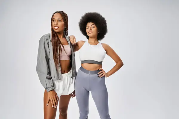 Jeunes femmes afro-américaines en forme posant ensemble sur fond gris, concept Juneteenth — Photo de stock