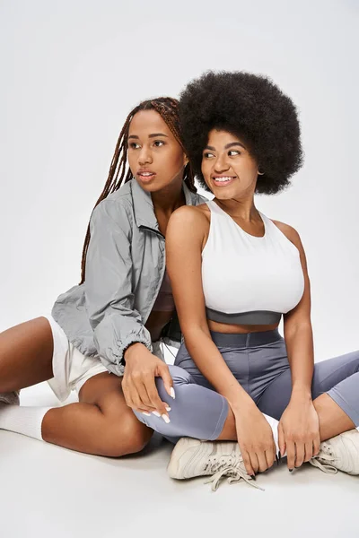 Schöne junge afrikanisch-amerikanische Frauen posieren zusammen auf grauem Hintergrund, Konzept vom Juni — Stockfoto