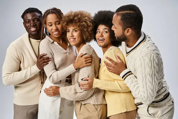 Groupe de gais afro-américains en tenue élégante étreignant sur fond gris, le 10 juin — Photo de stock