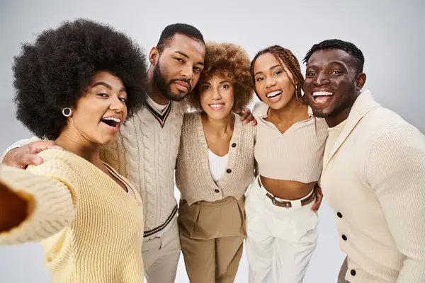 Gruppo di amici afro-americani sorridenti che legano e abbracciano su sfondo grigio, Juneteenth — Foto stock