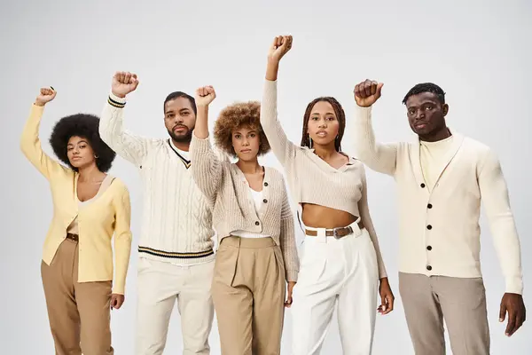 Двадцатое июня и активизм, счастливые африканские американцы с сжатыми кулаками на сером фоне — стоковое фото