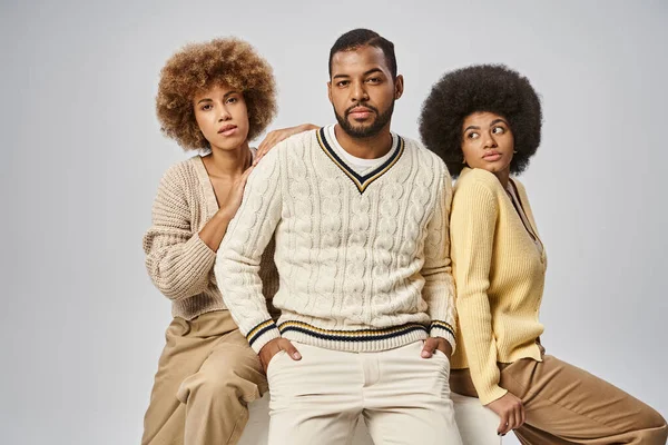 Two curly african american women in casual attire near man on grey background, Juneteenth concept — Stock Photo