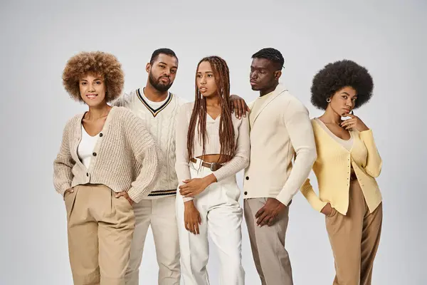 Jóvenes afroamericanos en atuendo casual de pie sobre fondo gris, concepto Juneteenth - foto de stock
