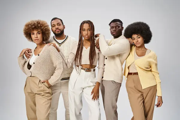 Atractivo afroamericano en traje casual de pie sobre fondo gris, concepto Juneteenth - foto de stock