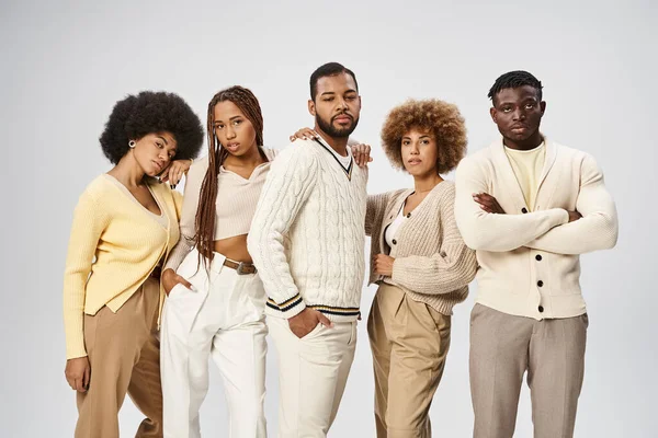 Jóvenes afroamericanos en trajes casuales de pie sobre fondo gris, concepto Juneteenth - foto de stock