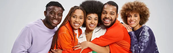 Cheerful african american people in colorful casual wear having fun together on grey, banner — Stock Photo