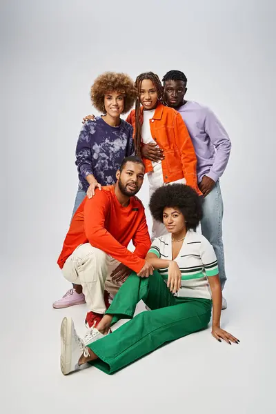 Cheerful african american people in colorful casual wear spending time together on grey background — Stock Photo
