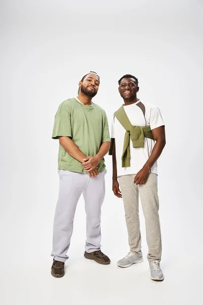 Joyeux hommes afro-américains en tenue décontractée debout ensemble sur fond gris, le 10 juin — Photo de stock