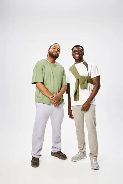 Joyeux hommes afro-américains en tenue décontractée debout ensemble sur fond gris, le 10 juin — Photo de stock