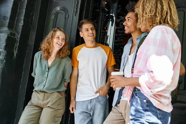 Fröhliche und stilvolle multiethnische Freunde reden in der Nähe der Herberge auf der Straße der Stadt, Freundschaft und Reisen — Stockfoto
