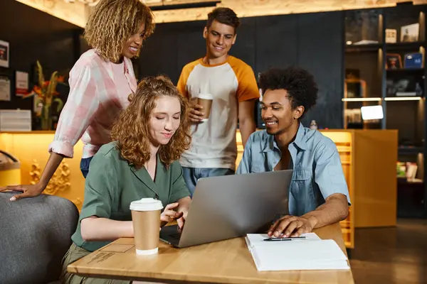 Smiling woman using laptop near multiethnic mates in lounge cafe of hostel, learning and travel — Stock Photo