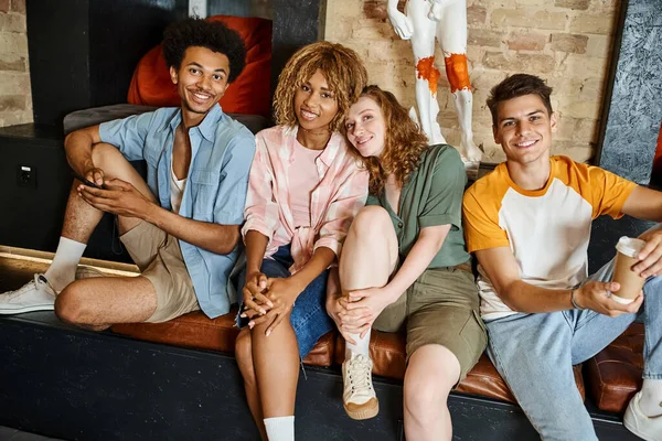 Jeunes et joyeux amis multiethniques regardant la caméra dans le salon de l'auberge d'étudiants modernes — Photo de stock