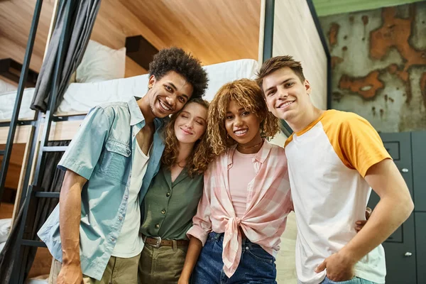 Diverso grupo de estudiantes multiculturales sonriendo a la cámara en la habitación de albergue moderno, amistad - foto de stock