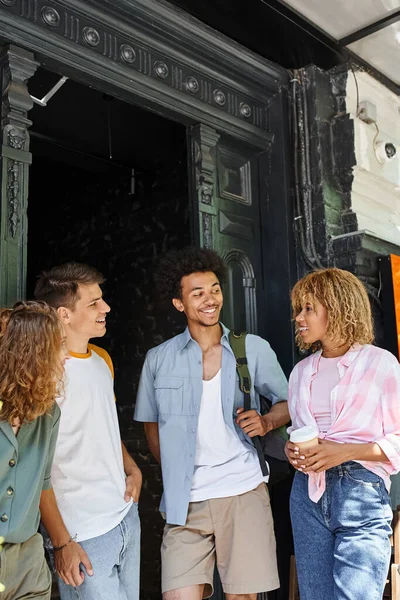 Радісні мультикультурні друзі розмовляють біля молодіжного хостелу на міській вулиці, дружбі та подорожах — стокове фото