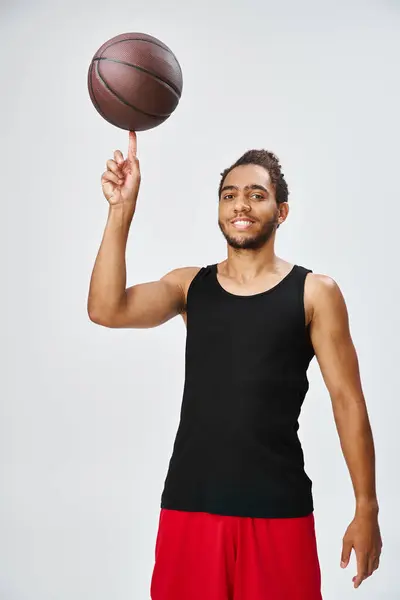 Atraente homem americano africano alegre em sportwear segurando basquete e olhando para a câmera — Fotografia de Stock