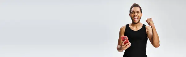 Joyeux sportif afro-américain tenant le téléphone et regardant la caméra, paris en ligne, bannière — Photo de stock