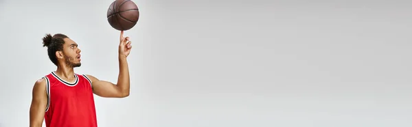Appealing athletic african american man in sportwear playing basketball on gray background, banner — Stock Photo