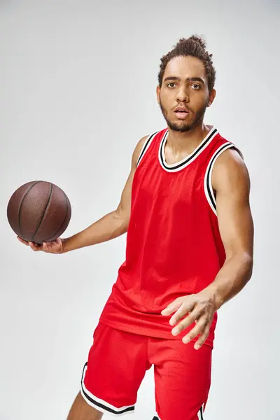 Attractive athletic african american man in vivid sportwear holding basketball and looking at camera — Stock Photo