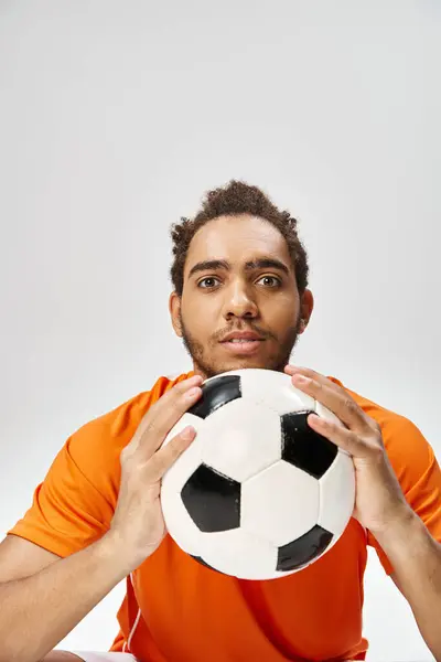 Handsome african american man posing with football and looking at camera on gray background — Stock Photo