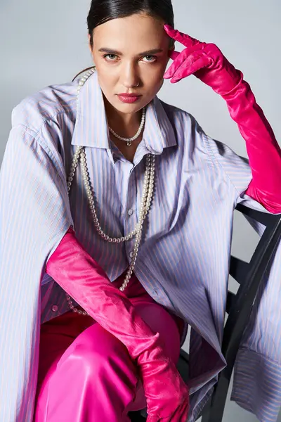 Brünette Frau mit rosa Handschuhen und stylischem Outfit, berührt ihre Stirn — Stockfoto