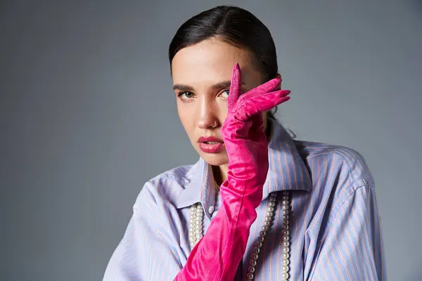 Donna alla moda con piercing in abito elegante e guanti rosa, coprendo il viso con la mano — Foto stock