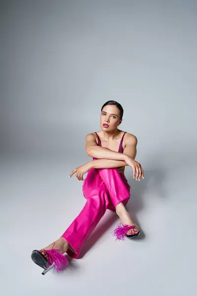 Mulher morena confiante na moda top vermelho e rosa calças e sapatos, sentado cruzando as pernas — Stock Photo