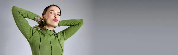 Portrait de femme brune fantaisie dans le vert total look branché baisers soufflant à la caméra, bannière — Photo de stock