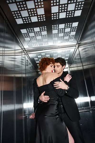 Sexy belo casal em elegante vestido preto e terno abraçando amorosamente no elevador após a data — Fotografia de Stock