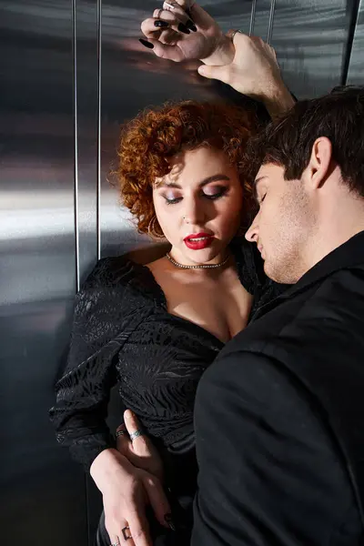 Engaging sexy couple in elegant black dress and suit hugging lovingly in elevator after date — Stock Photo