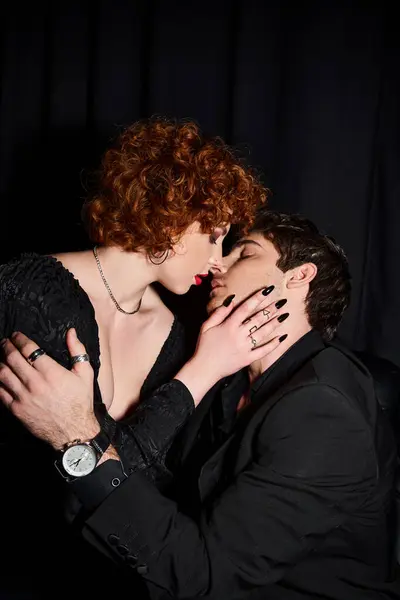 Attrayant petit ami et petite amie en tenue chic embrasser passionnément sur fond noir, couple — Photo de stock