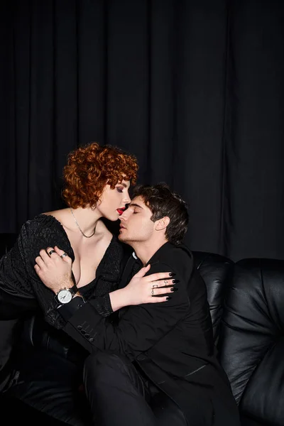 Tentador namorado e namorada em traje chique beijando apaixonadamente no fundo preto, casal sexy — Fotografia de Stock