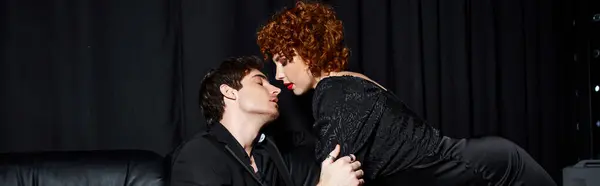 Atractivo novio y novia en elegante ropa abrazándose en sofá negro, sexy pareja, pancarta - foto de stock