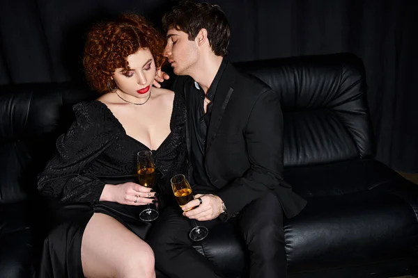 Appealing girlfriend and boyfriend spending quality time on sofa with champagne glasses, sexy couple — Stock Photo